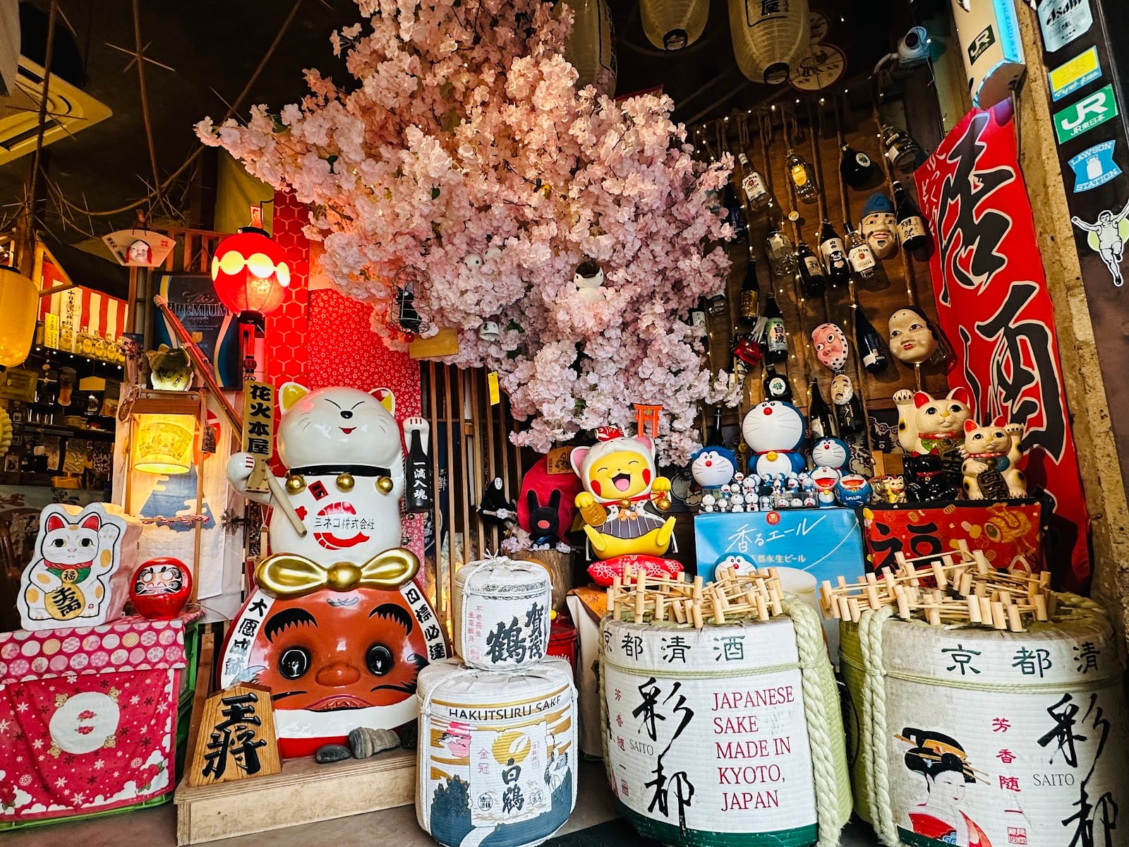 Hanabi Robata Izakaya Mount Austin entrance corner with a maneki-neko, cherry blossom display and Kyoto sake barrels