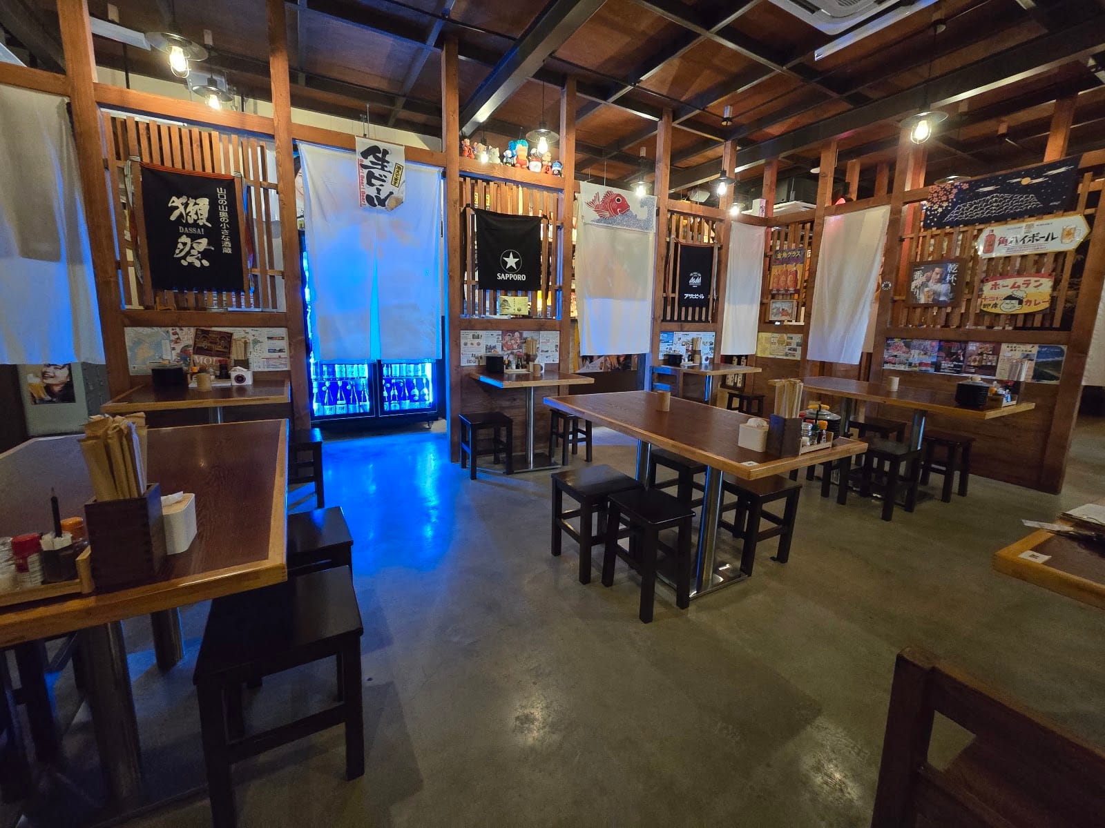 Dining room at Hanabi Robata Izakaya Kulai with sake banners on the wooden walls