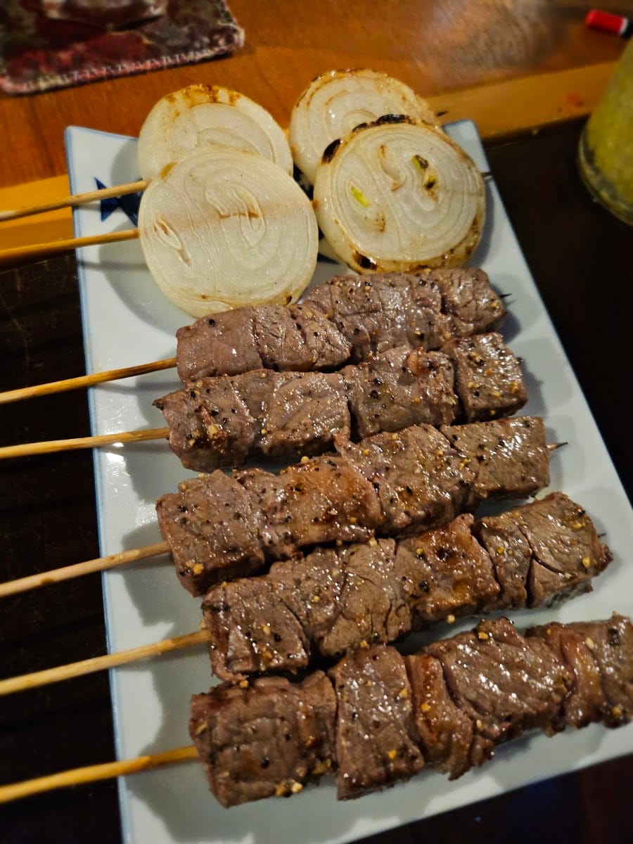 Grilled beef skewers with charred onion at Mount Austin