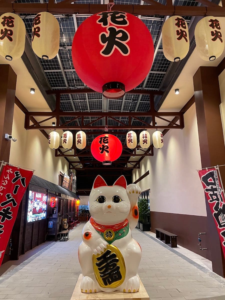 Large maneki-neko statue under a 花火 lantern at the Kulai mall entrance